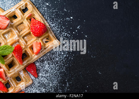 Hausgemachte Waffeln mit frischen Erdbeeren (auf dunklem Hintergrund) Stockfoto