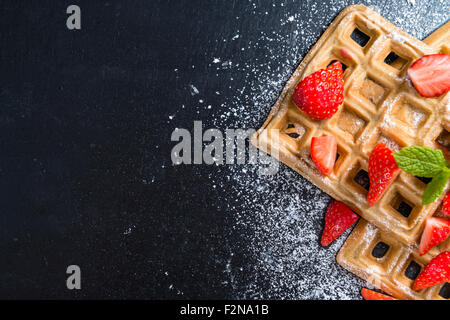 Waffeln mit frischen Erdbeeren (detaillierte Nahaufnahme) auf dunklem Hintergrund Stockfoto