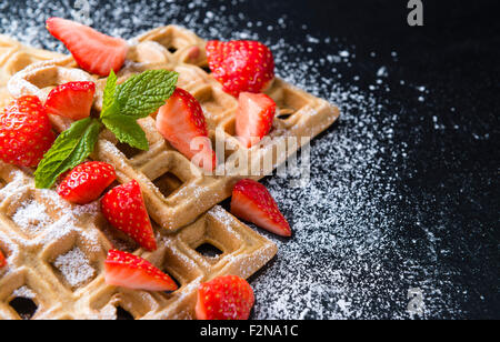 Hausgemachte Waffeln mit frischen Erdbeeren (auf dunklem Hintergrund) Stockfoto