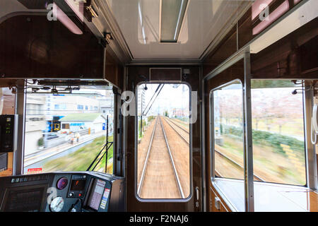 Japan, Osaka. Hankyu Eisenbahn. Blick durch die Treiber Kabinenfenster vorne am Zug wie es Geschwindigkeiten entlang der Strecke in der Stadt Osaka. Bewegungsunschärfe. Stockfoto