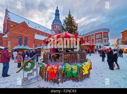 RIGA, Lettland - 28. Dezember 2014: Traditionelle europäische Weihnachtsmarkt auf der wichtigsten Platz der Altstadt (Domplatz) in Lettland an einem verschneiten Wintertag Stockfoto