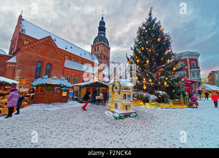 RIGA, Lettland - 28. Dezember 2014: Traditionelle europäische Weihnachtsmarkt in Riga Dome Square (Lettland) an einem verschneiten Wintertag Stockfoto