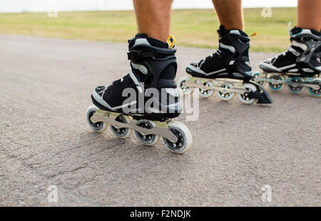 Nahaufnahme der Beine in Skates Skaten auf Straße Stockfoto