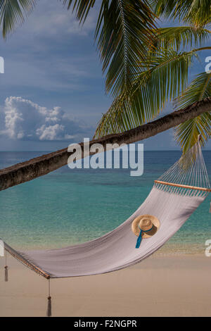 Sonnenhut in leere Hängematte am Strand Stockfoto