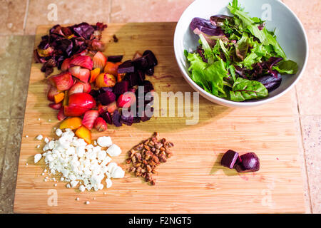 Geschnittenen Früchten, Nüssen und Käse mit Salatschüssel Stockfoto