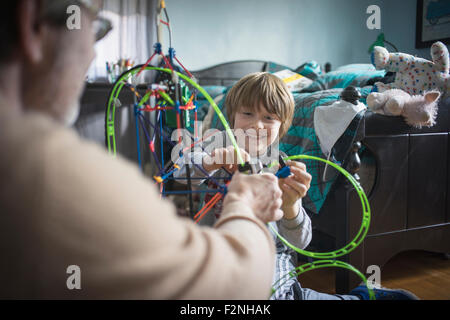 Kaukasische Vater und Sohn spielen mit Spielzeug im Schlafzimmer Stockfoto