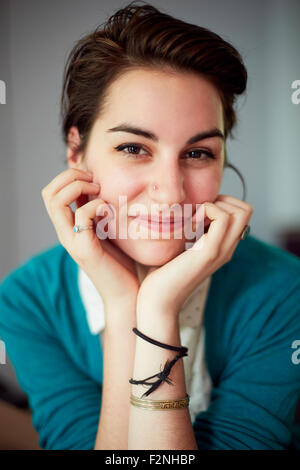 Nahaufnahme von Frau ruht Kinn in Händen Stockfoto