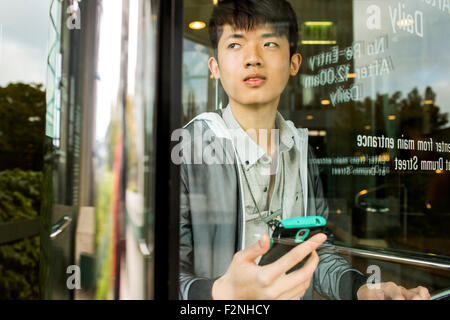 Asiatischen Mann mit Handy in Tür Stockfoto