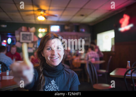 Kaukasische Frau mit Pommes-frites in der Bar Stockfoto