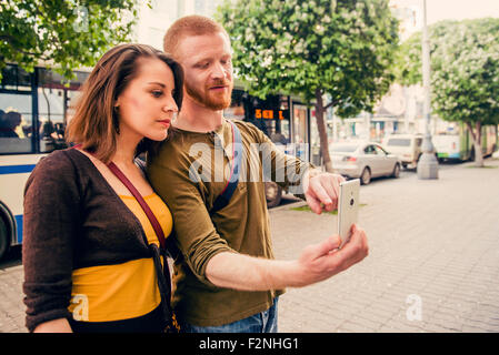 Kaukasische paar mit Handy auf Stadt Bürgersteig Stockfoto