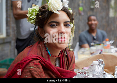 Lächelnde Frau mit Blumen und Schal hautnah