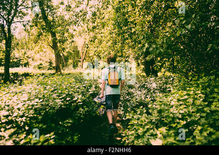 Kaukasischen Mann Wandern in üppigen park Stockfoto