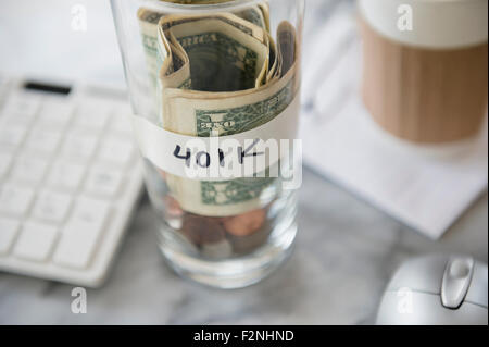 Nahaufnahme von Einsparungen Cup am Schreibtisch Stockfoto