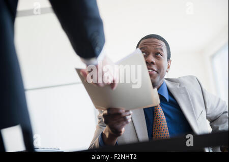 Geschäftsmann Übergabe Ordner an Chef im Büro Stockfoto