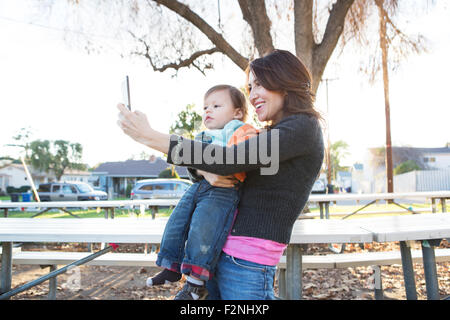 Hispanische Mutter nehmen Selfie mit Sohn im park Stockfoto