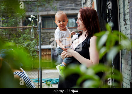 Frau mit Baby Sohn im Hinterhof Stockfoto