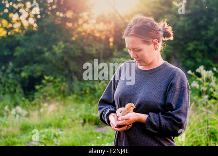 Kaukasische Frau Holding Küken im Garten Stockfoto