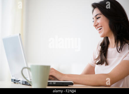 Frau mit Laptop mit Tasse Kaffee Stockfoto