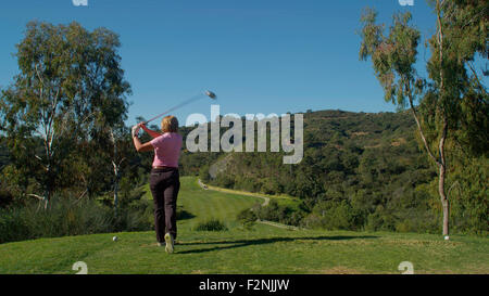 Kaukasische Frau Abschlag am Golfplatz Stockfoto