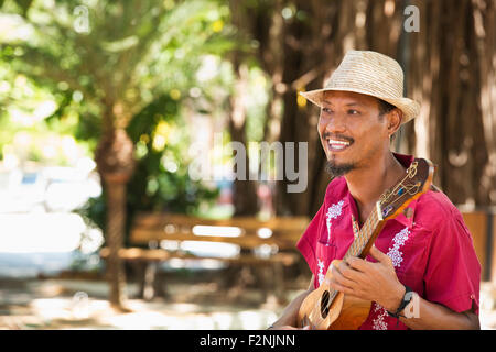 Lateinamerikanische Musiker spielt Ukulele im park Stockfoto