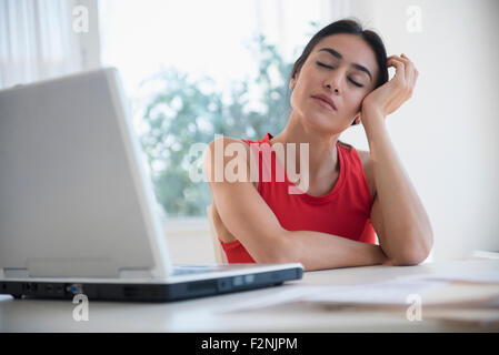 Betonte Geschäftsfrau sitzen am Laptop an der Rezeption Stockfoto