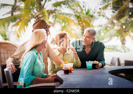 Paare mit Cocktails an Terrassenbar Stockfoto