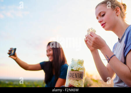 Mädchen im Teenageralter fotografieren und entspannen im freien Stockfoto