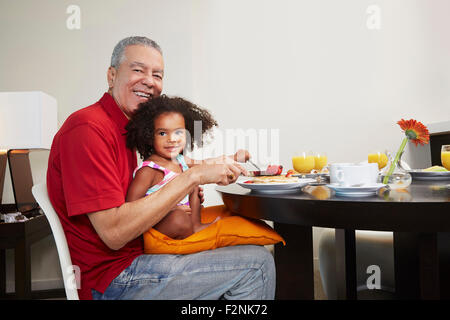 Großvater und Enkelin Essen Frühstück am Tisch Stockfoto