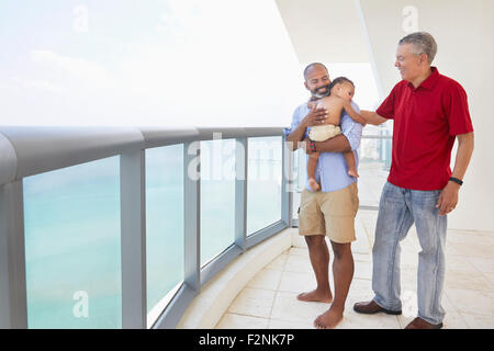 Drei Generationen von Männern stehend auf Balkon Stockfoto