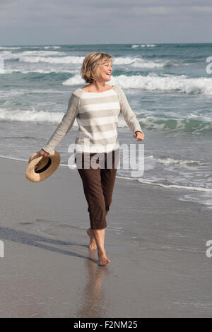 Kaukasische Frau zu Fuß am Strand Stockfoto