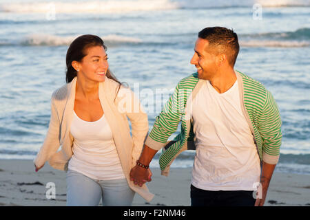 Hispanische paar halten die Hände am Strand Stockfoto