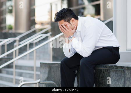 Betonte Mischlinge Geschäftsmann bedeckte sein Gesicht Stockfoto