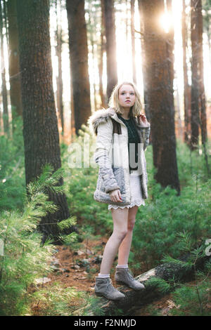 Kaukasische Frau auf Baum-Protokoll im Wald Stockfoto