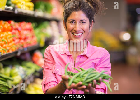 Hispanic Frau mit Gemüse im Supermarkt Stockfoto