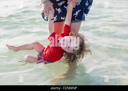 Kaukasische Mutter und Baby Sohn spielen am Strand