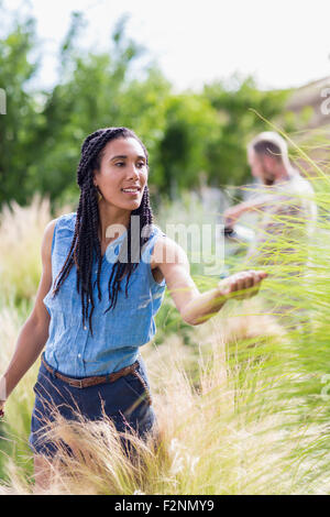 Frau, Prüfung von hohen Pflanzen im Garten Stockfoto