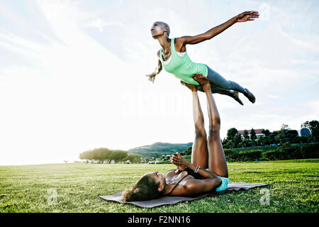 Frau und Freund praktizieren Acro Yoga im park Stockfoto