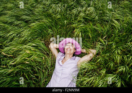 Kaukasische Frau Verlegung in hohe Gräser Stockfoto