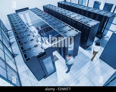 Erhöhte Ansicht von Technikern zu Fuß im Serverraum Stockfoto