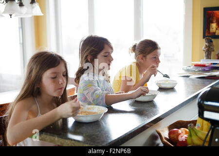 Kaukasische Schwestern frühstücken in Küche Stockfoto