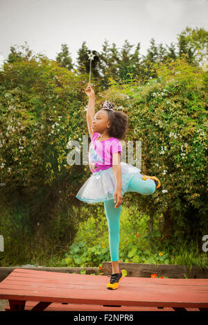 Schwarze Mädchen spielen Ballerina auf Picknick-Tisch Stockfoto