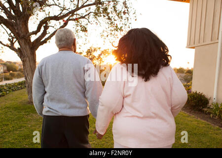 Rückansicht des Paares zu Fuß im Hinterhof Stockfoto