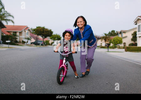 Großmutter Enkelin Vorort Straße Fahrrad Reitpony Lehre Stockfoto