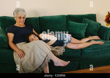 Großmutter und Enkeltochter sitzen auf dem Sofa im Wohnzimmer Stockfoto