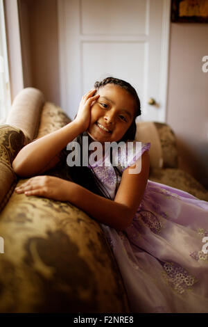 Hispanischen Mädchen sitzt auf dem Sofa im Wohnzimmer Stockfoto