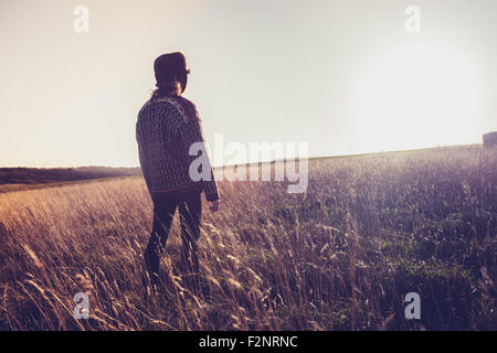 Frau im Feld bei Sonnenuntergang Stockfoto