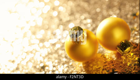 Goldene Weihnachtskugeln auf Glitzer Hintergrund Stockfoto
