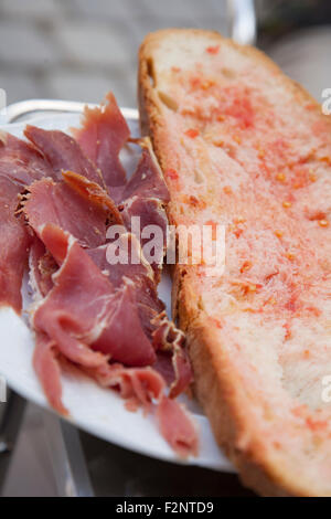 Spanischer Schinken (Jamón Serraño) serviert mit traditionelle katalanische "Pa Amb Tomàquet" (Brot mit Tomate) Stockfoto