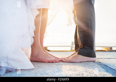 Füße von einer Braut und Bräutigam stehen am pier Stockfoto