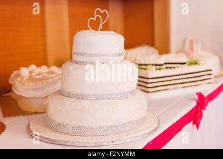 Ein Multi Level weiße Hochzeitstorte auf einen Tisch gelegt Stockfoto